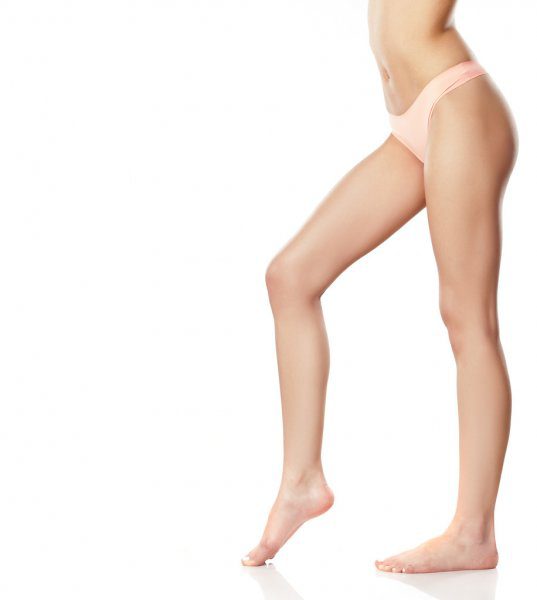 A woman in underwear standing on one leg.